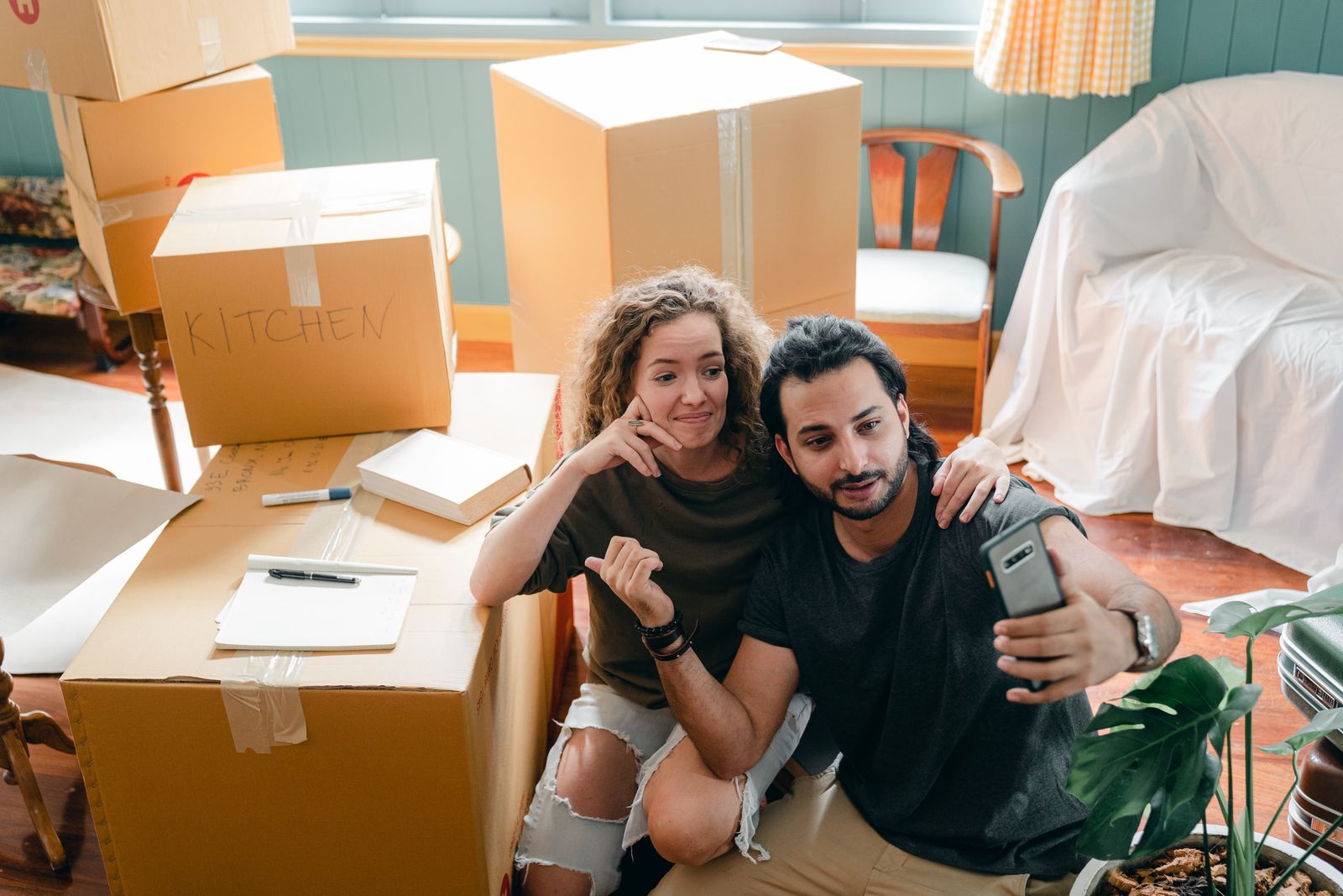 Couple resting among moving boxes in their new home